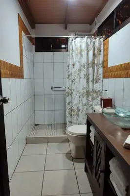 a bathroom with a shower with a toilet and a sink at Aventura Familiar Bosque Tropical Volcán Arenal in San Ramón