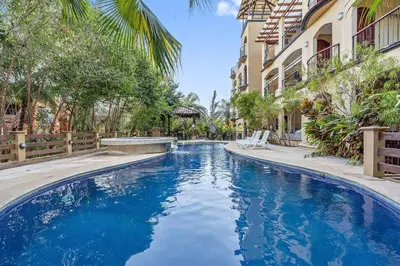 a pool with blue water in front of a building at Gav10 Modern Pool Side Condo in Quiet Area of Tam in Tamarindo