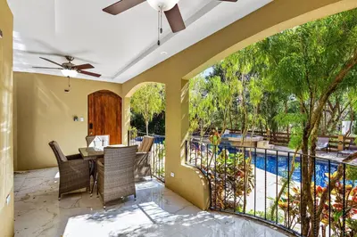 a patio with a table and chairs and a pool at Gav10 Modern Pool Side Condo in Quiet Area of Tam in Tamarindo