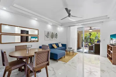 a living room with a blue couch and a table at Gav10 Modern Pool Side Condo in Quiet Area of Tam in Tamarindo