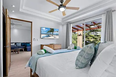 a bedroom with a bed with a ceiling fan at Gav5 New Modern Condo Walking Distance to Beach in Tamarindo