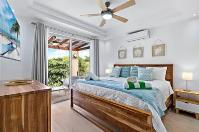 a bedroom with a bed with a ceiling fan at Gav5 New Modern Condo Walking Distance to Beach in Tamarindo