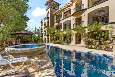 an exterior view of a building with a swimming pool at Gav5 New Modern Condo Walking Distance to Beach in Tamarindo