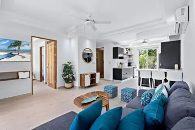 a living room with a blue couch and a table at Gav5 New Modern Condo Walking Distance to Beach in Tamarindo