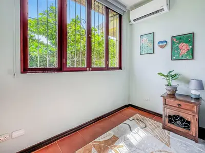 a room with a large window and a table with a plant at LSI1 Cozy 2 Bdrm Villa Central and Steps to Beach in Tamarindo