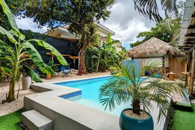 a swimming pool with a palm tree in a yard at Matambú Main House in Cuajiniquil