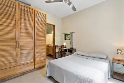 a bedroom with a bed and a table and a desk at Matambú Main House in Cuajiniquil
