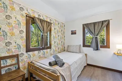 a bedroom with a bed and two windows at Matambu Entire Complex in Cuajiniquil