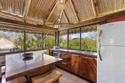 a kitchen with a white refrigerator and some windows at Matambu Entire Complex in Cuajiniquil