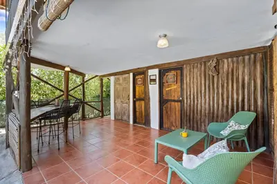 a porch with chairs and a table and a table at Matambu Entire Complex in Cuajiniquil