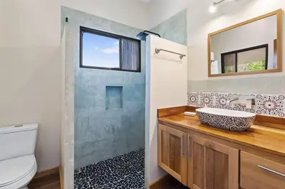 a bathroom with a sink and a toilet and a mirror at Matambu Entire Complex in Cuajiniquil