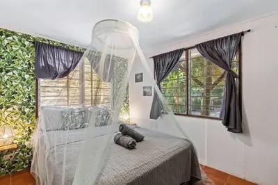 a bedroom with a bed with a mosquito net at Matambú Ranchita Charming & Rustic with Shared Pool in Matapalo