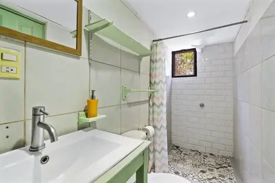 a bathroom with a sink and a toilet and a shower at Matambú Ranchita Charming & Rustic with Shared Pool in Matapalo