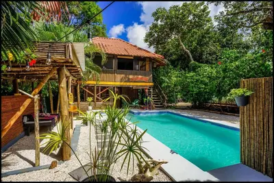 a house with a swimming pool next to a house at Matambú Rancho Rustic 2bd Apt with Shared Pool in Matapalo
