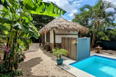 a small hut next to a swimming pool at Matambú Rancho Rustic 2bd Apt with Shared Pool in Matapalo
