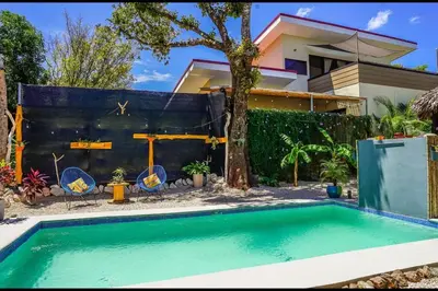 a swimming pool in front of a house at Matambú Rancho Rustic 2bd Apt with Shared Pool in Matapalo