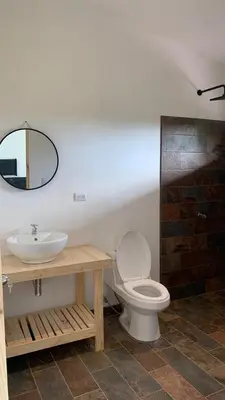 a bathroom with a sink and a toilet and a mirror at sarahs peaceful Home in Parrita