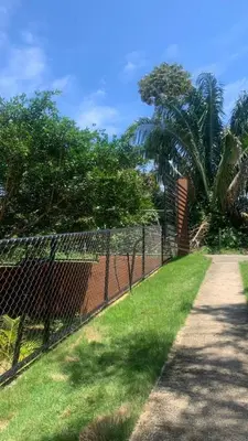 a chain link fence next to a field of grass at sarahs peaceful Home in Parrita