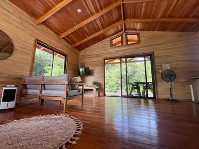 a living room with wooden walls and a wooden floor at Almond Suite - Blue Zone Costa Rica, Hojancha in Caimital
