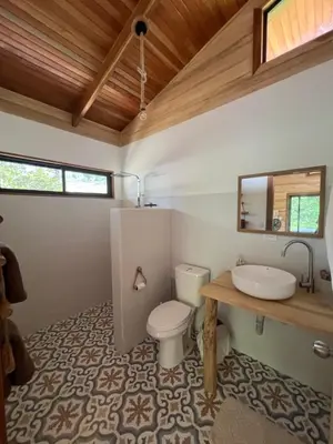 a bathroom with a toilet and a sink at Almond Suite - Blue Zone Costa Rica, Hojancha in Caimital