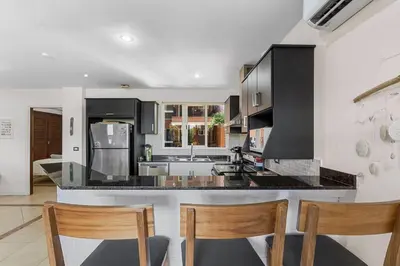 a kitchen with black cabinets and a counter top at Nax3 Luxury Condo in Upscale Langosta Community in Tamarindo