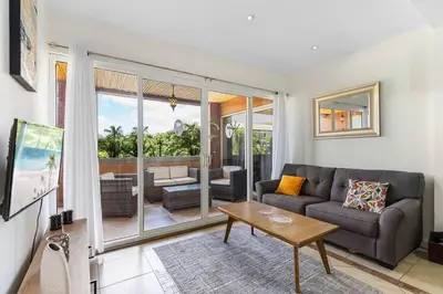 a living room with a couch and a table at Nax3 Luxury Condo in Upscale Langosta Community in Tamarindo