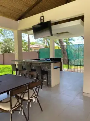 a patio with a grill and tables and chairs at Pen16 Luxury 3bd Condo in Excl Resort Complex in Tamarindo