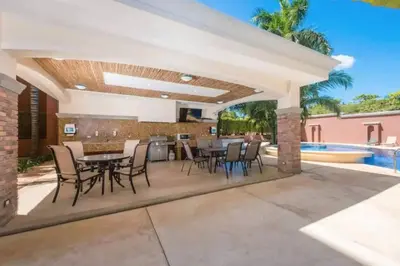 a patio with a table and chairs and a pool at Pen16 Luxury 3bd Condo in Excl Resort Complex in Tamarindo
