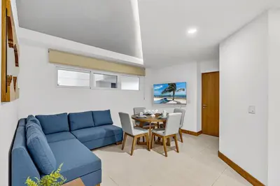 a living room with a blue couch and a table at Pen16 Luxury 3bd Condo in Excl Resort Complex in Tamarindo