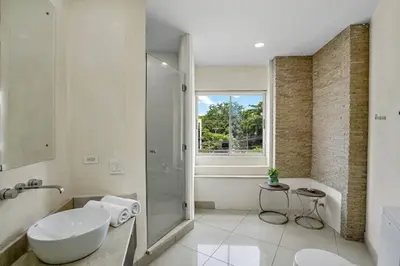 a white bathroom with a sink and a shower at PP201 Modern Space in Centre of Town in Tamarindo