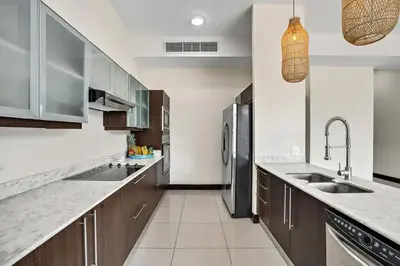 a kitchen with wooden cabinets and stainless steel appliances at PP201 Modern Space in Centre of Town in Tamarindo