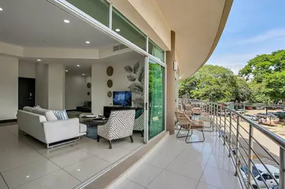 a balcony with a couch and a table and chairs at PP201 Modern Space in Centre of Town in Tamarindo