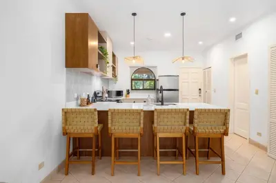 a kitchen with a island with bar chairs at SR9 Luxury Condo Across the Street from Beach in Tamarindo