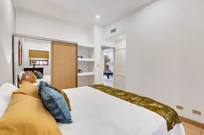 a bedroom with a large white bed with blue pillows at SR9 Luxury Condo Across the Street from Beach in Tamarindo