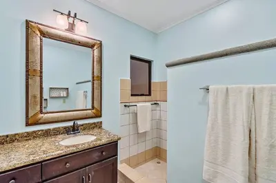 a bathroom with a sink and a mirror at SR9 Luxury Condo Across the Street from Beach in Tamarindo