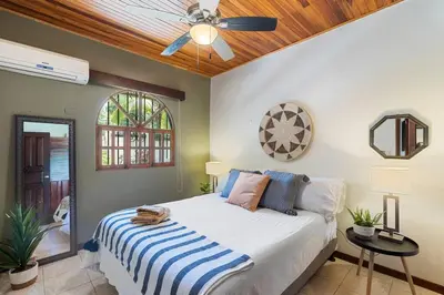 a bedroom with a bed and a ceiling fan at VBM1 Beachside Cottage Steps from the Shore in Tamarindo