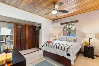 a bedroom with a bed and a ceiling fan at VBM1 Beachside Cottage Steps from the Shore in Tamarindo