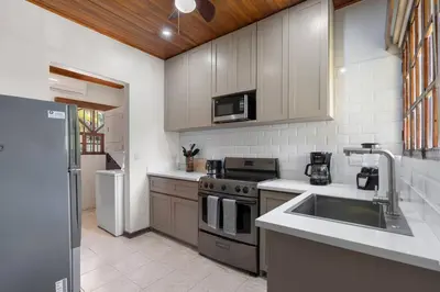 a kitchen with a sink and a stove at VBM1 Beachside Cottage Steps from the Shore in Tamarindo