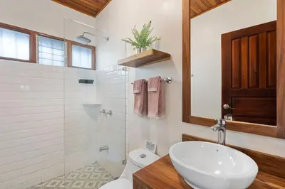 a bathroom with a sink and a shower and a toilet at VBM1 Beachside Cottage Steps from the Shore in Tamarindo