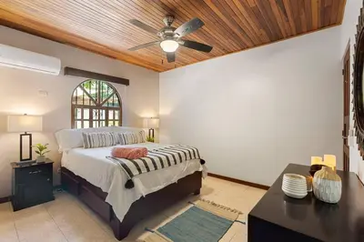 a bedroom with a bed and a ceiling fan at VBM1 Beachside Cottage Steps from the Shore in Tamarindo