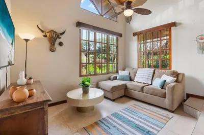 a living room with a couch and a cow head on the wall at VBM1 Beachside Cottage Steps from the Shore in Tamarindo