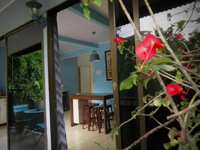 a view of a living room and a kitchen with a table and chairs at Rose House Manuel Antonio in Quepos