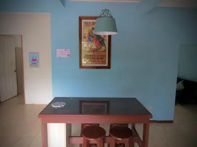 a dining room table with stools and a picture on the wall at Rose House Manuel Antonio in Quepos