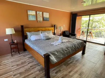 a bedroom with a large bed in a room at Cabinas La Catarata in Fortuna