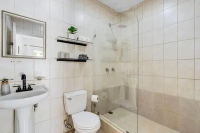 a bathroom with a shower and a toilet and a sink at VVII2 2 bdrm with ensuite bathrms in centre of town in Tamarindo
