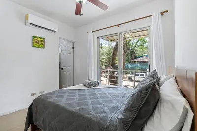 a bedroom with a bed and a large window at VVII2 2 bdrm with ensuite bathrms in centre of town in Tamarindo