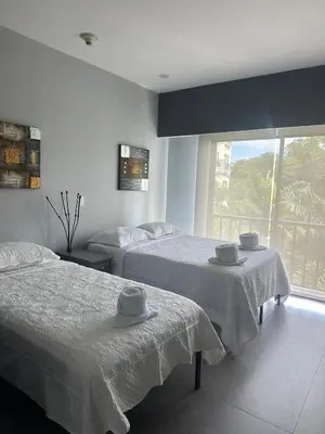 a bedroom with two beds and a large window at Casa blue in Jacó