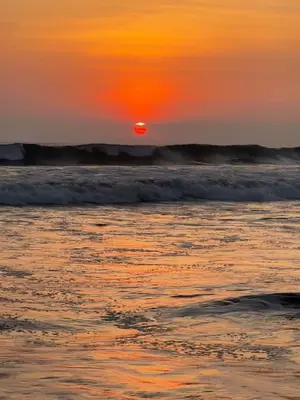 a sunset over the ocean with waves at Casa blue in Jacó