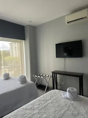 a bedroom with two beds and a flat screen tv at Casa blue in Jacó