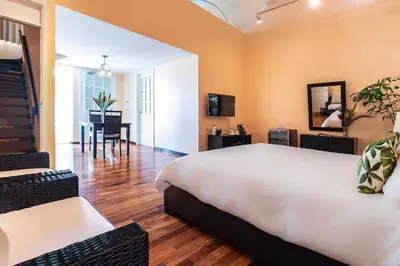 a bedroom with a large bed and a dining room at Gaia Collection Hotels Manuel Antonio in Manuel Antonio